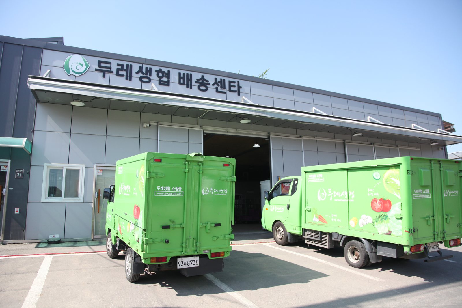 두레생협 배송센터 앞에 나란히 선 초록빛 배송 차량들